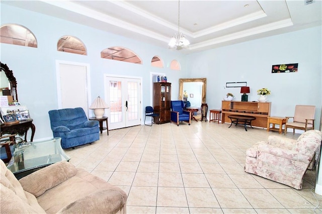 tiled living room with a towering ceiling, a chandelier, french doors, and a raised ceiling