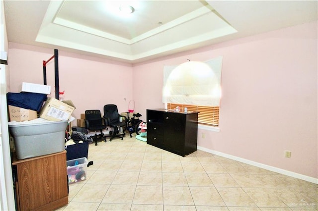 office space with light tile patterned flooring and a tray ceiling