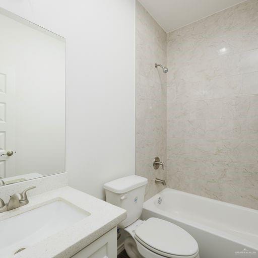 full bathroom with vanity, tiled shower / bath combo, and toilet