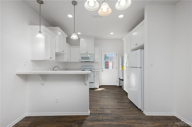 kitchen with white appliances, kitchen peninsula, hanging light fixtures, a kitchen bar, and white cabinetry