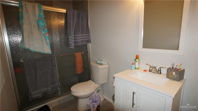 bathroom featuring toilet, vanity, and walk in shower