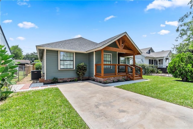 1018 N Keralum Ave, Mission, TX 78572 - view of front of house with covered porch, roof with shingles, concrete driveway, and central AC unit