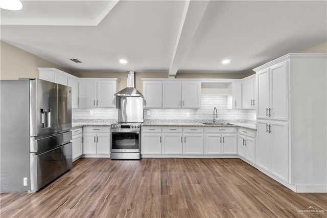1018 N Keralum Ave, Mission, TX 78572 - kitchen with stainless steel appliances, wall chimney exhaust hood, a sink, white cabinetry, and decorative backsplash