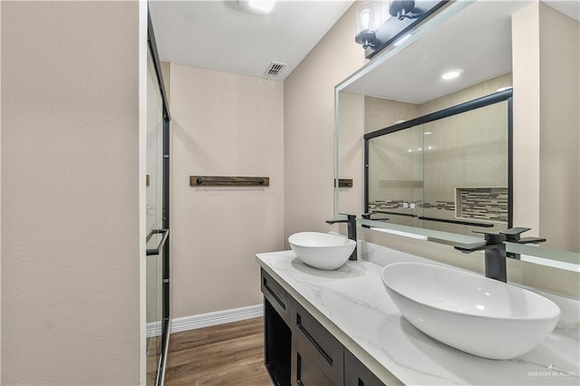 1018 N Keralum Ave, Mission, TX 78572 - bathroom with a stall shower, double vanity, wood finished floors, and baseboards