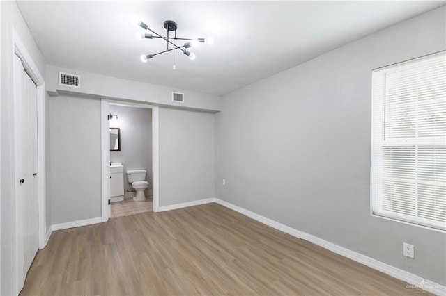7201 S San Marcos St, Pharr, TX 78577 - unfurnished bedroom featuring light wood finished floors, a chandelier, a closet, baseboards, and connected bathroom