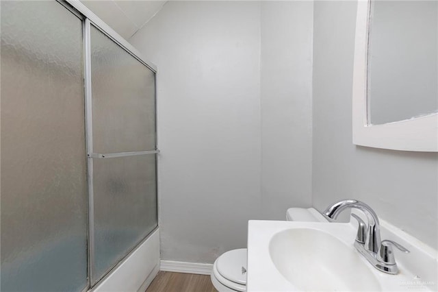 7201 S San Marcos St, Pharr, TX 78577 - bathroom featuring a sink, toilet, bath / shower combo with glass door, wood finished floors, and baseboards