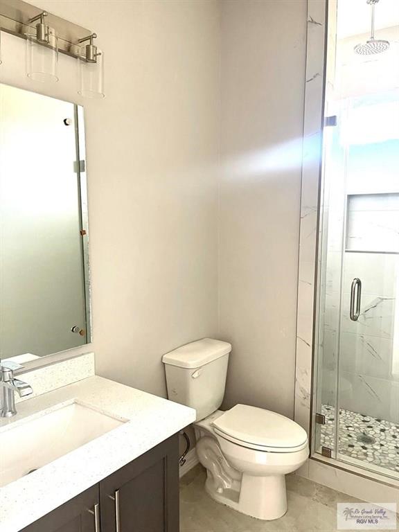 full bath with toilet, a stall shower, and vanity