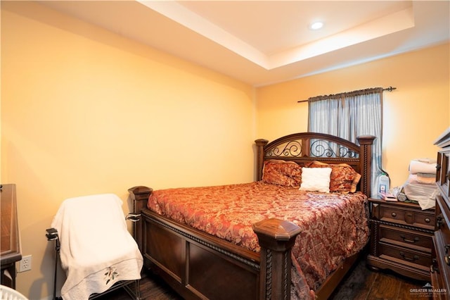 bedroom featuring dark hardwood / wood-style flooring and a tray ceiling