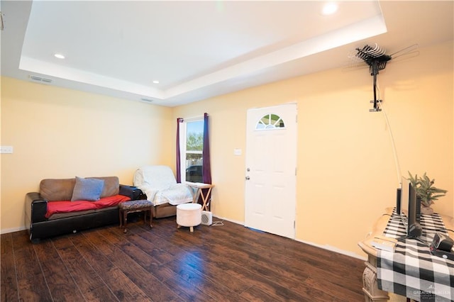 sitting room featuring dark hardwood / wood-style flooring and a tray ceiling