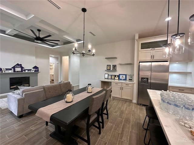 dining area featuring beam ceiling, ceiling fan with notable chandelier, and coffered ceiling