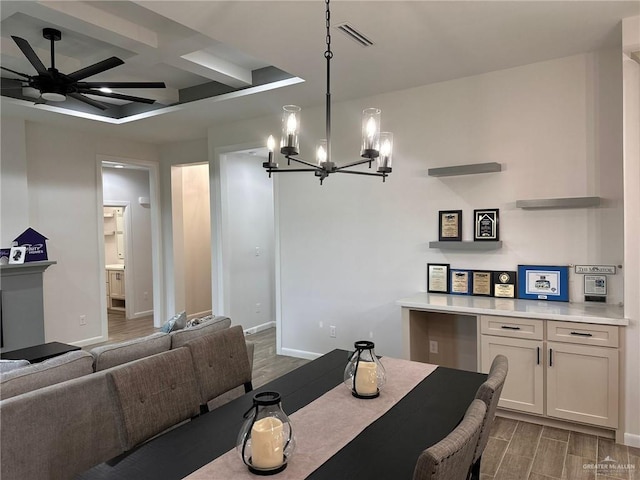 dining room featuring ceiling fan with notable chandelier, beam ceiling, and coffered ceiling