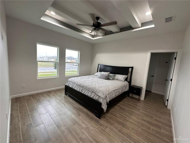 bedroom with ceiling fan and a tray ceiling