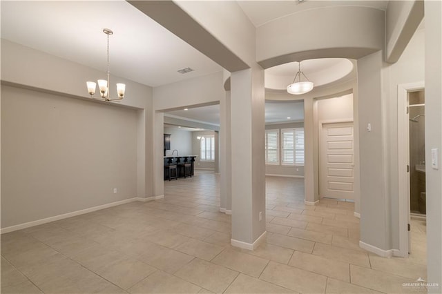 hall featuring a chandelier and light tile patterned floors