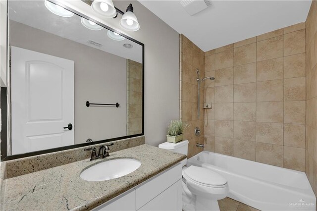 full bathroom with vanity, tiled shower / bath, and toilet