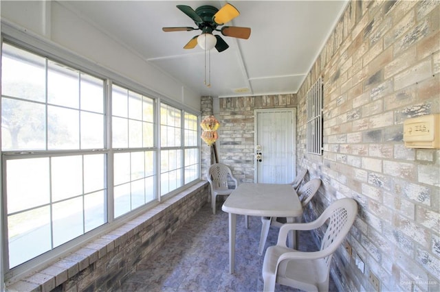 unfurnished sunroom with ceiling fan