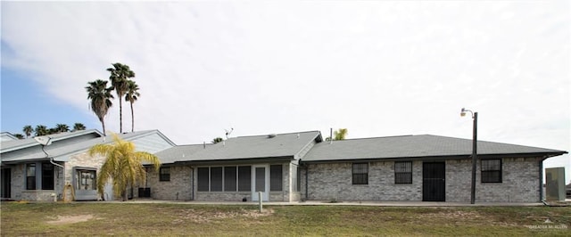 back of property with a lawn and a patio area