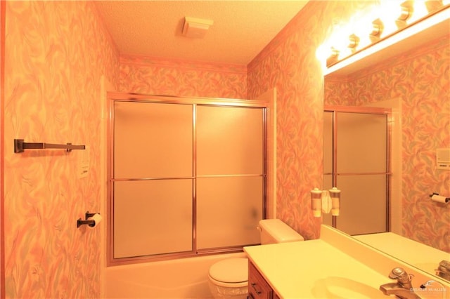 full bathroom with toilet, vanity, bath / shower combo with glass door, and a textured ceiling