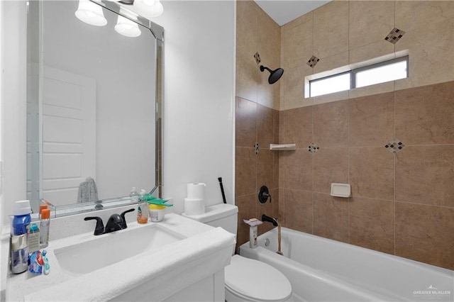 full bathroom featuring tiled shower / bath combo, vanity, and toilet