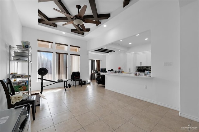 interior space with coffered ceiling, ceiling fan, beamed ceiling, and a high ceiling