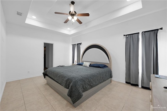 bedroom featuring a tray ceiling, ceiling fan, and light tile patterned flooring