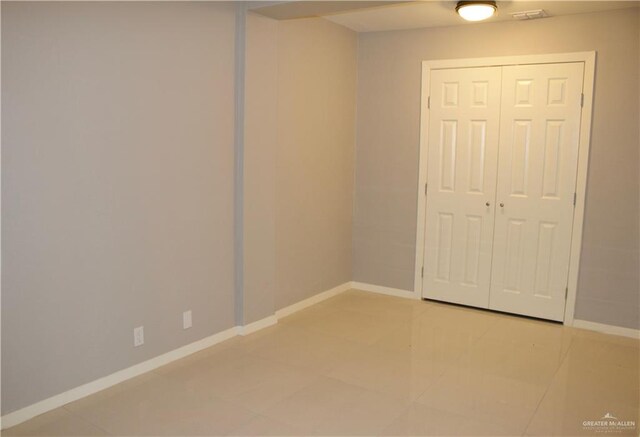 unfurnished bedroom with a closet and light tile patterned floors