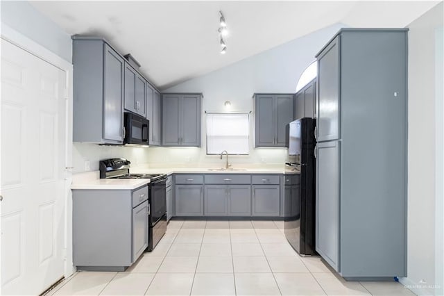 kitchen with gray cabinets, a sink, black appliances, vaulted ceiling, and light countertops