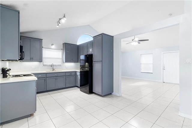 kitchen with black appliances, a ceiling fan, a sink, light countertops, and vaulted ceiling