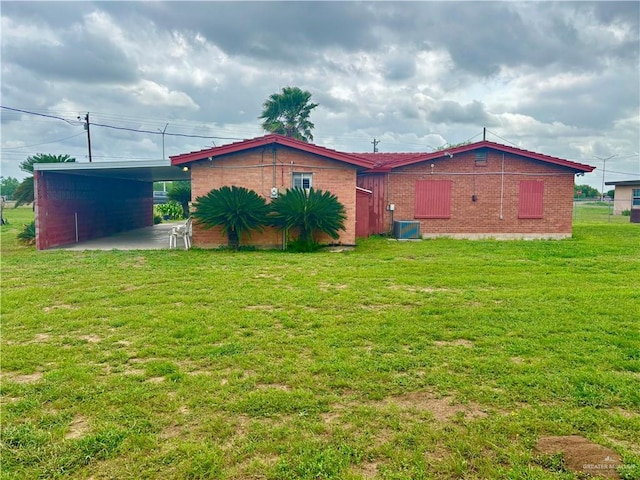 31665 US Highway 281, Edinburg, TX 78542 - back of house with brick siding, a lawn, central AC, and an attached carport