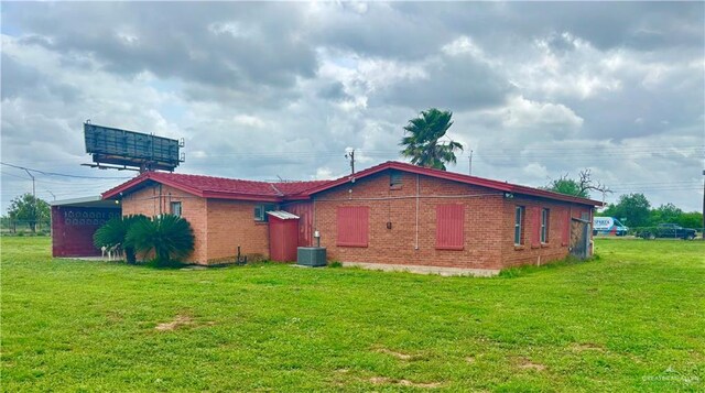 31665 US Highway 281, Edinburg, TX 78542 - view of side of property with central AC, brick siding, and a yard