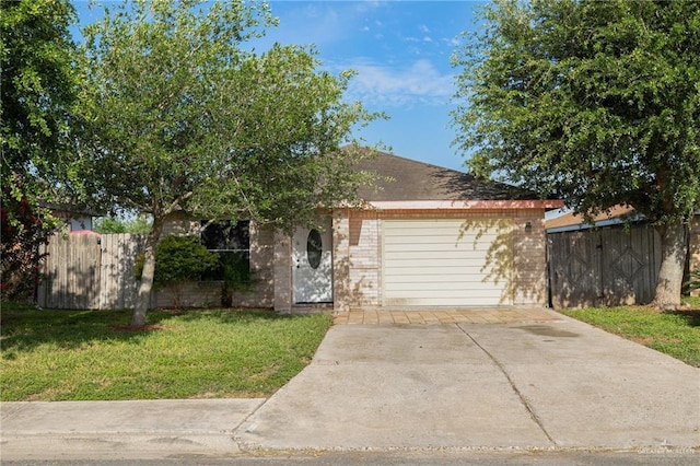 477 Serg Loop, Alamo, TX 78516 - view of front of house featuring fence, a front lawn, brick siding, and a garage