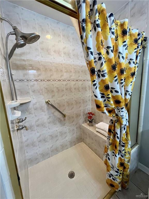 bathroom with a shower with curtain and tile patterned flooring