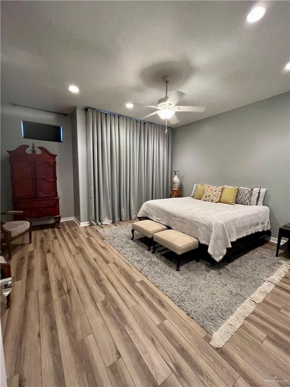 bedroom with ceiling fan and light hardwood / wood-style flooring