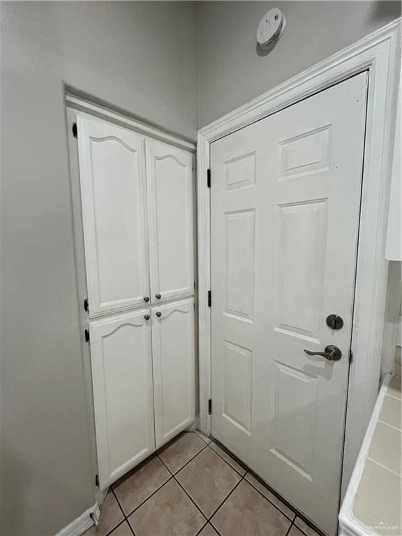 doorway to outside with light tile patterned flooring