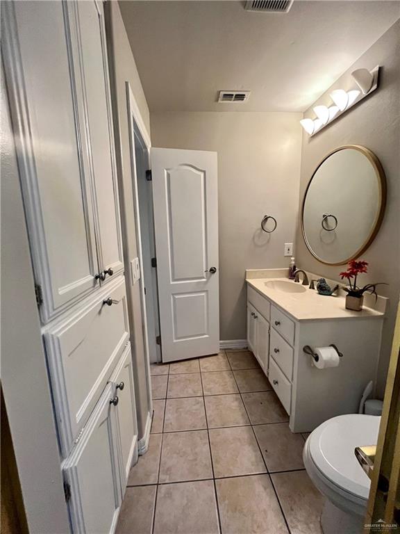 bathroom with tile patterned flooring, vanity, and toilet