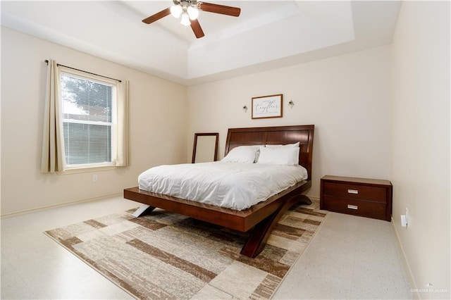 bedroom featuring a tray ceiling and ceiling fan