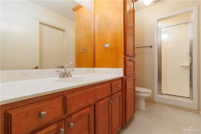 bathroom with vanity, toilet, and a shower with door