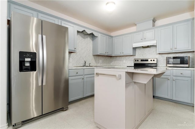 kitchen featuring sink, appliances with stainless steel finishes, gray cabinetry, a center island, and decorative backsplash