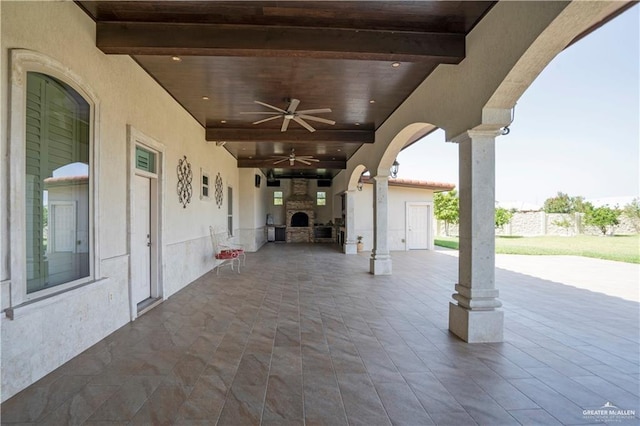 view of patio / terrace with an outdoor stone fireplace and ceiling fan