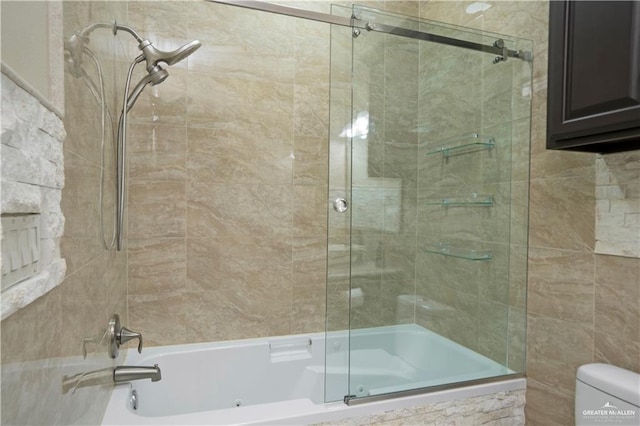 bathroom featuring combined bath / shower with glass door and toilet