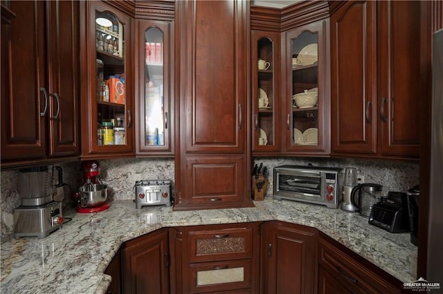 kitchen with decorative backsplash and light stone counters