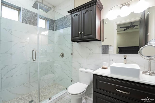 bathroom with ceiling fan, an enclosed shower, toilet, decorative backsplash, and tile walls