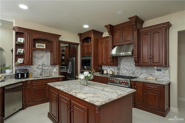 kitchen featuring light stone countertops, sink, decorative backsplash, a kitchen island, and appliances with stainless steel finishes