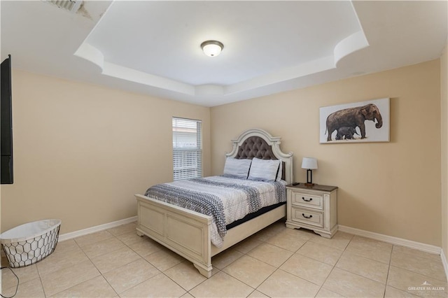 bedroom with light tile patterned floors, baseboards, visible vents, and a tray ceiling