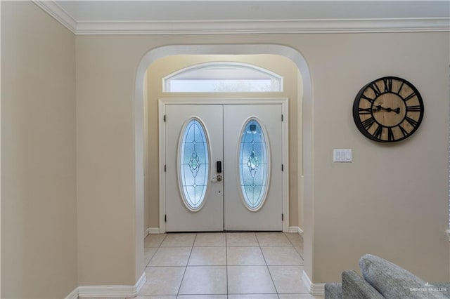 entrance foyer featuring crown molding, baseboards, and light tile patterned floors