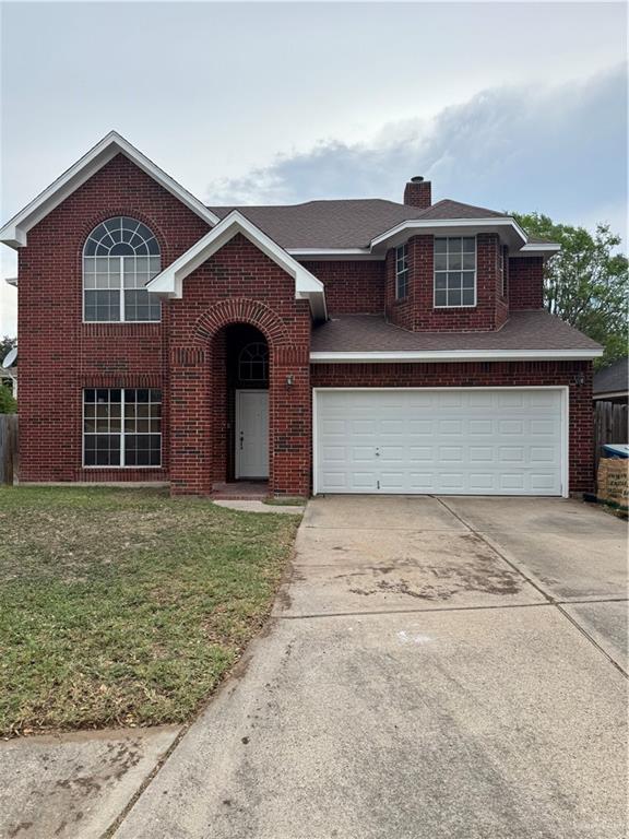 traditional-style home featuring an attached garage, a front lawn, brick siding, a chimney, and concrete driveway
