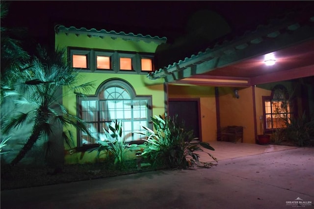 exterior entry at night with stucco siding