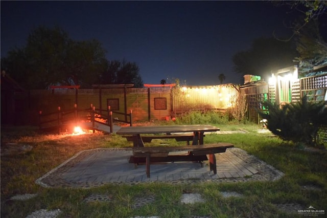 yard at twilight featuring a patio area and fence