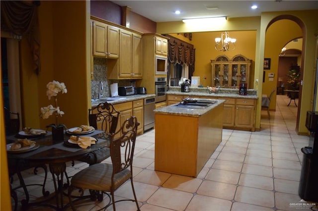 kitchen featuring a sink, backsplash, a center island, arched walkways, and appliances with stainless steel finishes