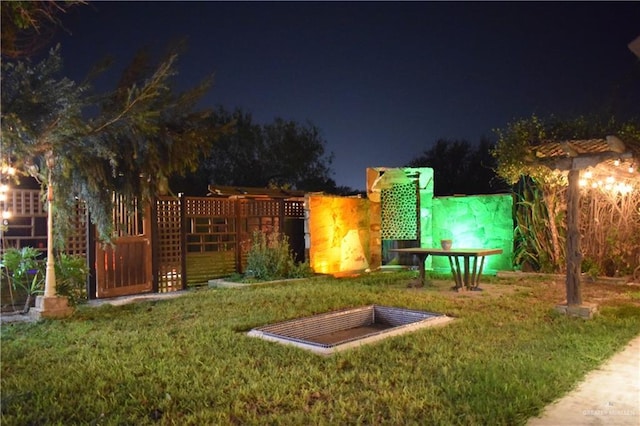 yard at night featuring fence