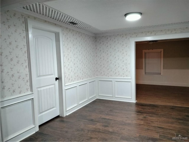 9458 Charles Green Rd, Edcouch, TX 78538 - unfurnished room with wallpapered walls, wainscoting, dark wood finished floors, and a decorative wall